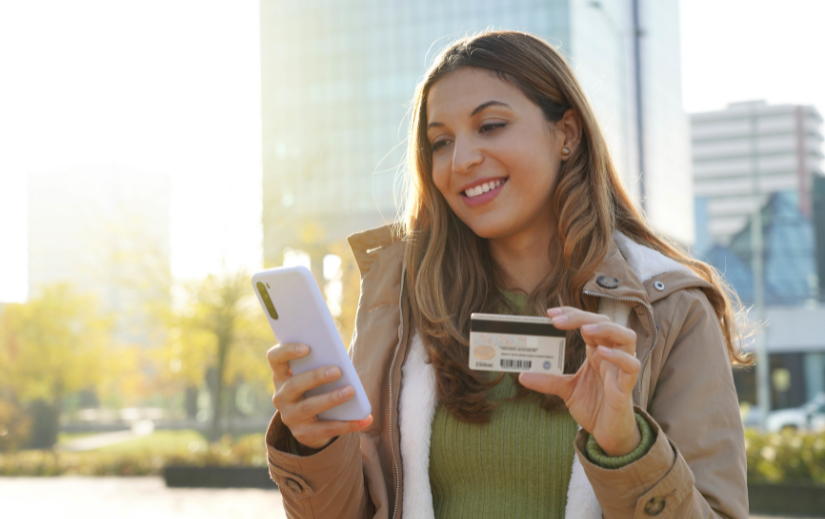 Woman shopping online with a smartphone and credit card, highlighting optimization techniques for eCommerce success.